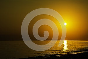 Horizontal sunset coastline calm sea with golden sun - Late afternoon on beach waterline with golden direct sunset calm sea ocean