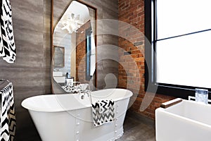 Horizontal version freestanding vintage style bath tub in renovated warehouse apartment