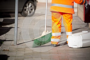 Horizontal View of a Dustman Cleaning the Street With a Mop Wear photo