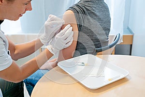 Horizontal view of a female doctor disinfecting a female patient`s arm after a vaccination