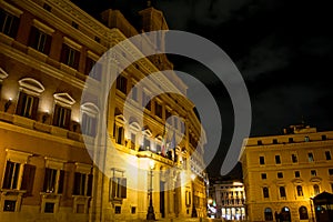 Horizontal View of the Italian Parliament Building, Montecitorio, at Night Illuminated by Warm Lights on Cloudy Night Sky