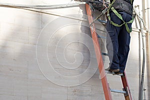 Horizontal View of a Tecnician Working on a Ladder With Safety T photo