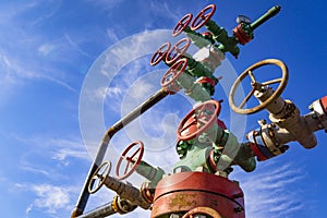 Horizontal view of a wellhead with valve armature. Oil and gas industry concept. Industrial site background. Toned photo