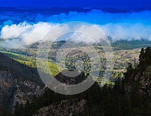 Horizontal vivid cloudscape in mountain forest background