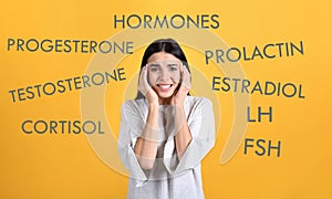 Hormones imbalance. Stressed young woman and different words on yellow background