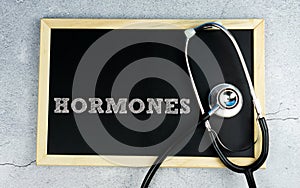 HORMONES wrote on chalkboard with stethoscope