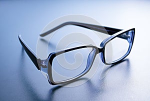 Horn-rimmed glasses on blue background photo