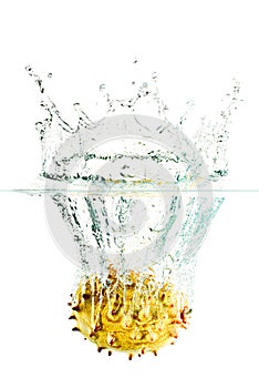 Horned melon falling into water splash on a white background