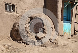 Horno - mud adobe outdoor oven in Southwestern US Pueblo community with old metal barrel top protecting the opening - common in al photo