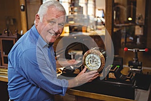 Horologist checking a clock in workshop