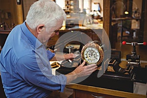 Horologist checking a clock in workshop