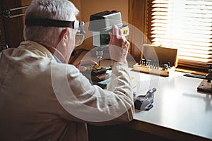 Horologist drilling a dial plate