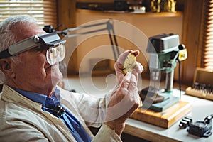 Horologist examining a clock part