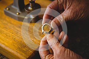 Horologist hand holding watch frame in workshop