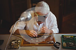 Horologist repairing a watch