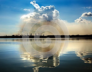 Horrible cloud of smog from a steel plant is reflected in water