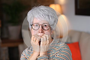 Horrified senior woman at home photo