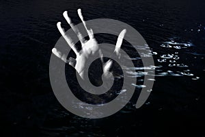 Horror background. Hand reaching out from water