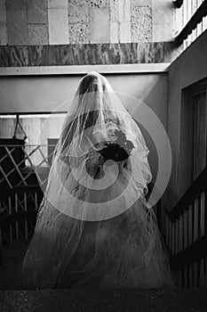 Horror scene of a scary woman in white dress in an abandoned building. Halloween scary concept