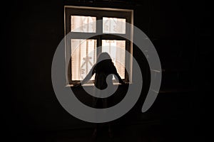 Horror woman in window wood hand hold cage scary scene halloween concept Blurred silhouette of witch. Horror theme