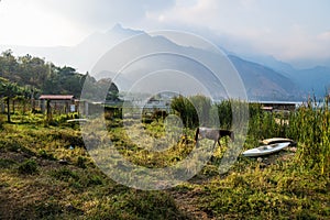 Horse and a canoe on a meadow along Lago Atitlan with mountainrange, San Juan la Laguna, Guatemala, Central America