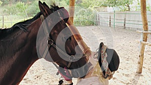 horse care. equestrian riding. beautiful rider girl is combing horse mane, stroking and hugging her horse. horse farm or