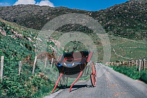 Horse carriage lies on the scenic road of Gap of Dunloe, a narrow mountain pass in county Kerry, Ireland on a sunny day