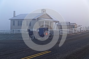 A Horse and Carriage Passes an Amish School House