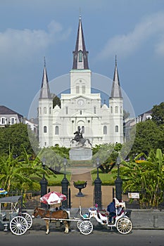 Horse Carriage and tourists in front of Andrew Jackson Statue & St. Louis Cathedral, Jackson Square in New Orleans, Louisiana