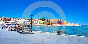 Horse carriages and lighthouse at the old harbor of Chania, Crete.