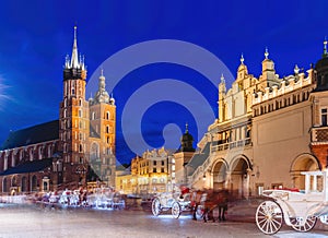 Horse carriages in the market square at the evening old town in Cracow, Poland