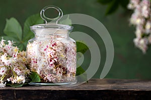 Horse chestnut flowers in a glass jar. Production of medicines, tablets, tinctures.