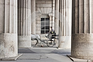 Horse-drawn carriage passing through the collonnade photo