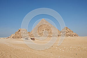 Horse drawn carts near Giza pyramids. Menkaure and pyramids Queens seen from desert