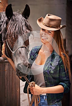 Horse, farm and ranch with young woman in barn or stable for work in agriculture or sustainability. Cowgirl, texas or