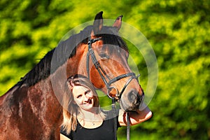 Horse and girl head portraits against a green background in the sunshine
