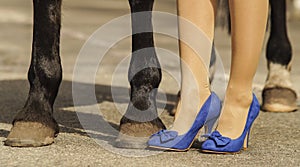 Horse hoof feet near the feet of woman shoes