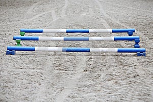 Horse obstacle course outdoors summertime. Poles in the sand at equestrian center outdoors