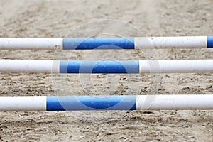 Horse obstacle course outdoors summertime. Poles in the sand at equestrian center outdoors