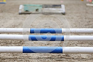 Horse obstacle course outdoors summertime. Poles in the sand at equestrian center outdoors