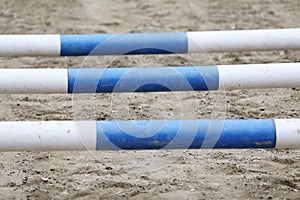 Horse obstacle course outdoors summertime. Poles in the sand at equestrian center outdoors