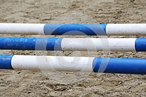 Horse obstacle course outdoors summertime. Poles in the sand at equestrian center outdoors