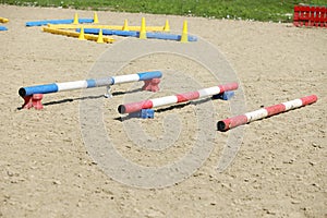 Horse obstacle course outdoors summertime. Poles in the sand at equestrian center outdoors