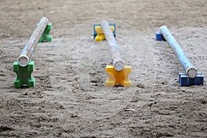 Horse obstacle course outdoors summertime. Poles in the sand at equestrian center outdoors