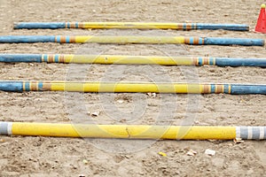 Horse obstacle course outdoors summertime. Poles in the sand at equestrian center outdoors