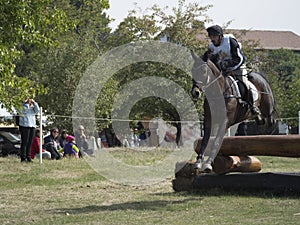 Horse rider jumping over a barrier