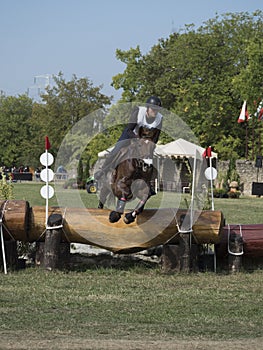 Horse rider jumping over a barrier