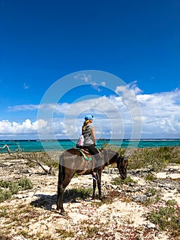 Horse riding tourists in Cuba. Girl on a horse on a beach