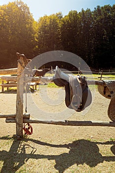 Horse saddle riding equipment on fence
