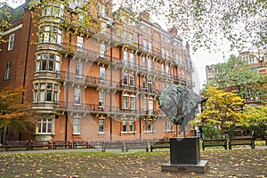 Horse sculpture in London park in autumn with vintage building background